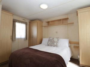 a bedroom with a bed in a small room at The Coop - Family Friendly caravan near Glastonbury & Street in Compton