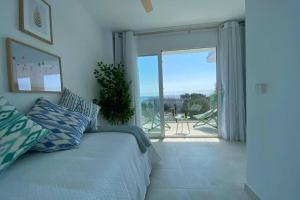 1 dormitorio con cama y vistas al océano en PENTHOUSE 6E WITH POOL , 150 METERS CANYAMEL BEACH, en Capdepera