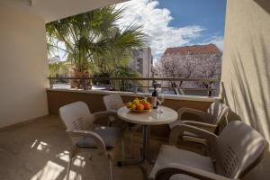 einen Balkon mit einem Tisch und Stühlen sowie einem Fenster in der Unterkunft Apartments Bogica in Makarska