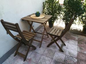 einen Holztisch und zwei Stühle auf einer Terrasse in der Unterkunft Fabrizi in Catania
