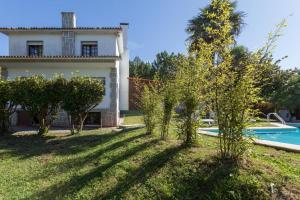 a villa with a pool and a yard with trees at Chalet paxariñas in Sanxenxo