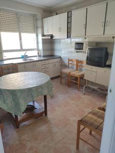 - une cuisine avec une table, des chaises et un évier dans l'établissement Casa Tonete, à San Justo de la Vega