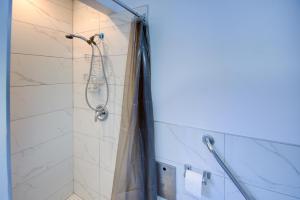 uma casa de banho com chuveiro e cortina de chuveiro em Les dortoirs de L'espace Globetrotter em Rimouski