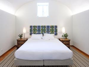 a bedroom with a large white bed with two night stands at ADC - Albergaria Do Calvário - by Unlock Hotels in Évora