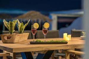 a wooden table with two glasses of wine on it at Villa Tranquillity in Kastraki Naxou