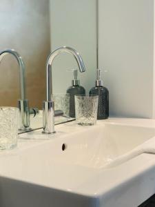 lavabo con 2 grifos y 2 vasos en Bed & Breakfast Karakter en Den Dungen