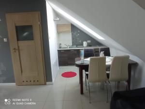 a kitchen with a table and chairs in a room at Słoneczne Zacisze in Wicko