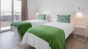 dwa łóżka w pokoju hotelowym z oknem w obiekcie Blancazul Villa Verode w mieście Playa Blanca +37 zdjęć