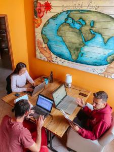a group of people sitting at a table with laptops at Tiberias Hostel in Tiberias