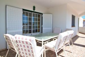 a patio with a table and chairs on a balcony at Quinta Das Flores, Lote 9 in Albufeira