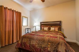 a bedroom with a bed and curtains and a fan at Two Bedroom Villa in the Heart of Branson! in Branson