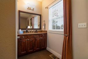 a bathroom with a sink and a mirror and a window at Two Bedroom Villa in the Heart of Branson! in Branson +15 photos