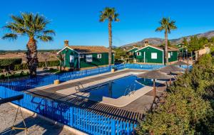 a swimming pool with palm trees and a house at ALEDORURAL in Aledo