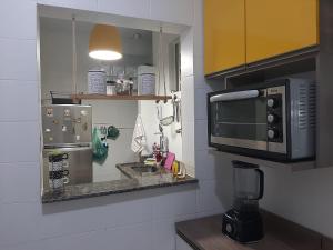 a small kitchen with a microwave and a sink at Studio em Copacabana in Rio de Janeiro