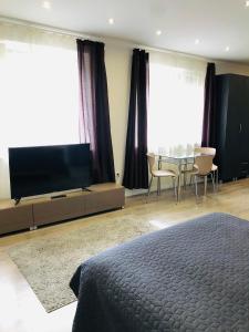1 dormitorio con 1 cama, TV y mesa en Mira apartman, en Debrecen