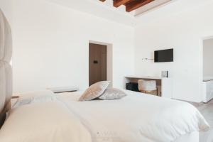 a bedroom with a white bed with two pillows at A-mare Exclusive Rooms & Suites in Taranto