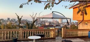 a white table and an umbrella on a fence at Cottage house Niniela in Batumi