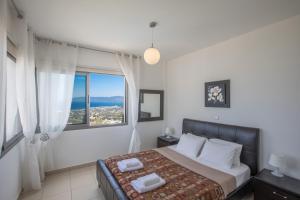 a bedroom with a bed and a large window at Esprit Villas in Polis Chrysochous +39 photos