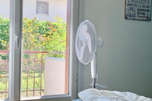 a fan in a room next to a window at #AL Le bleuet T2 with terrace in Échirolles +9 photos
