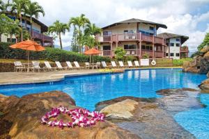 a pool at a resort with chairs and umbrellas at Club Wyndham Ka Eo Kai in Princeville
