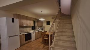 a kitchen with a staircase with a white refrigerator at Frigano 1 in Stoupa