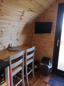 ein Zimmer mit einem Tisch und Stühlen in einer Hütte in der Unterkunft Lochview Pods in Harlosh