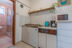 uma pequena cozinha com armários brancos e um lavatório em Apartment Antic S em Crikvenica