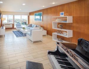 a living room with a couch and a piano at Club Wyndham Inn on Long Wharf in Newport