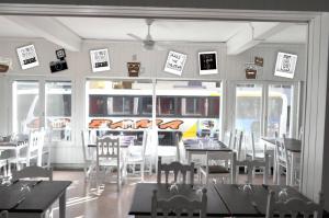 a dining room with tables and chairs and signs on the wall at Hotel Capri in Villa Gesell
