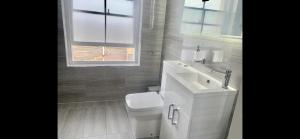 baño con aseo y lavabo y ventana en Master accommodation suite 3 sea view en Hastings