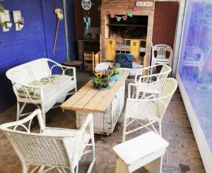 um pátio com cadeiras e uma mesa de madeira com flores em Alojamiento familiar em Coronel Suárez