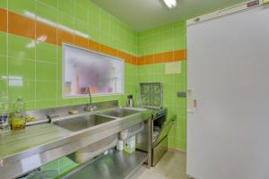 a kitchen with a sink and green tiles at Maison spacieuse avec jardin près de Le Bouffay in Commes +23 photos