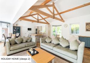 a living room with two couches and a kitchen at Cadnam Lodge in Cadnam