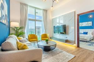 a living room with a couch and a tv at Live Modern Live Luxury - Dubai Studio City in Dubai
