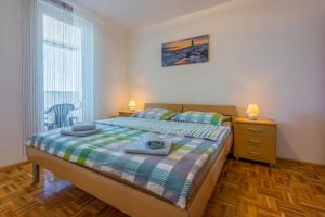 a bedroom with a bed and a dresser and a window at Apartment Ruzica in Crikvenica