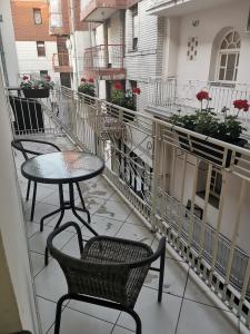 a balcony with two chairs and a table on a building at Nacional 1 Apartment Studio in Subotica