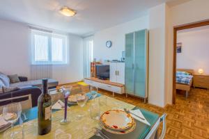 a living room with a table with a bottle of wine at Apartment Ruzica in Crikvenica +20 photos