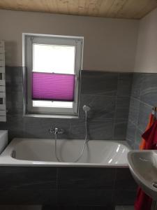a bathroom with a bath tub and a window at Ferienwohnung Groß in Königswalde +17 photos