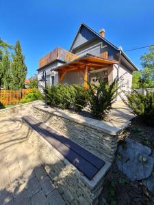 une maison avec une passerelle en pierre devant elle dans l'établissement Arborétum Nyaraló Szarvas - Kültéri jakuzzival, à Szarvas