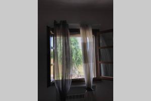 a window with curtains in a room at Agriturismo Il Salicchio app.Benedetta in Pian dʼAlma