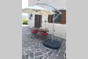 a table and chairs with an umbrella on a patio at Agriturismo Il Salicchio app.Benedetta in Pian dʼAlma
