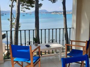 una mesa y sillas en un balcón con vistas al agua en Port Pollensa Pins Apartment sea view, en Puerto Pollensa