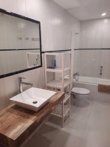 a bathroom with a white sink and a toilet at Port Pollensa Pins Apartment sea view in Port de Pollensa