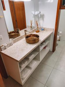 a bathroom counter with a sink and a mirror at BANGALÔS REFÚGIO DO VALE in Santa Maria do Erval