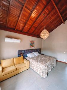 Santa Maria do ErvalにあるBANGALÔS REFÚGIO DO VALEのベッドとソファのある寝室