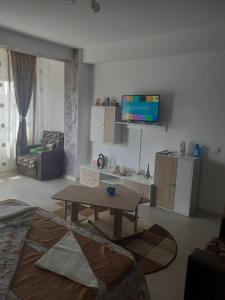 a living room with a table and a tv at Garsonieră SORIN in Eforie Nord