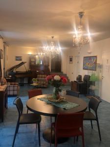 sala de estar con mesa, sillas y piano en Albergo Ristorante Pomodoro, en Omegna