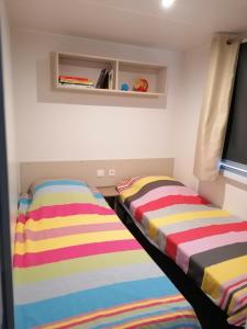 two beds sitting next to each other in a room at Superbe Mobil home "excellence" au MAR ESTANG in Canet-en-Roussillon