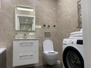 La salle de bains est pourvue de toilettes, d'un lavabo et d'un miroir. dans l'établissement 2 кімнатні ,Люкс апартаменти в ЖК Арена ,район автовокзалу, à Rivne