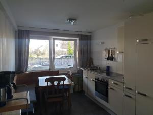 a small kitchen with a table and a window at Hotel Garni Haus Dithmarschen in Elpersbüttel